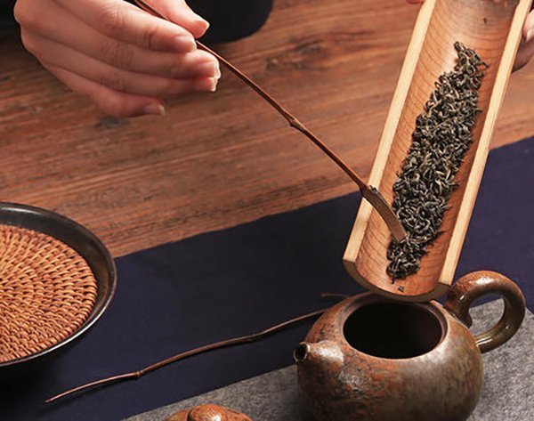 Using a tea stirrer to add tea from the teaspoon