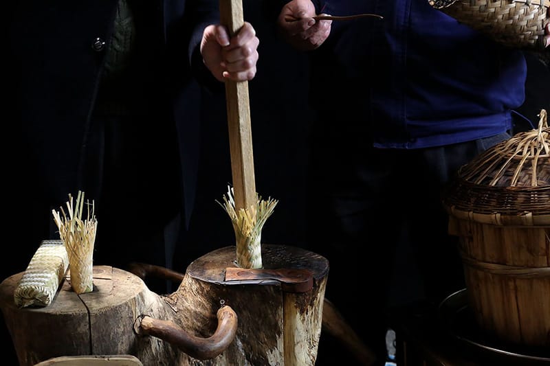 Pestling the Tibetan tea in a bamboo canes container