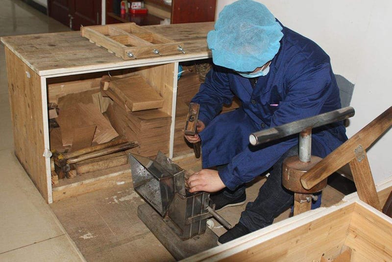 Tea master is compressing the brick tea
