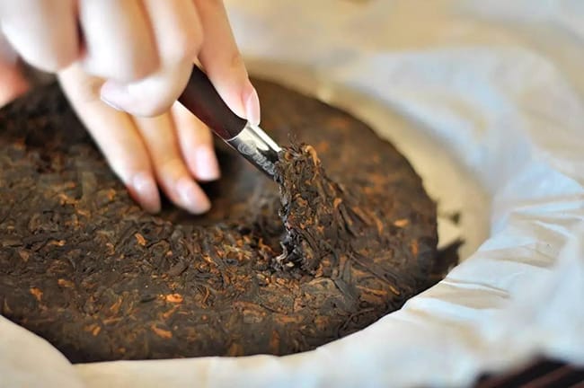 Dark tea cake need a knife to pry and get some splinters inevitably